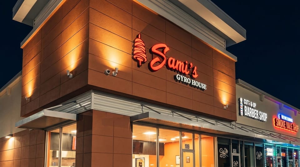 Exterior of Sami's Gyro House at night, with a glowing red sign and warm lighting on the building.
