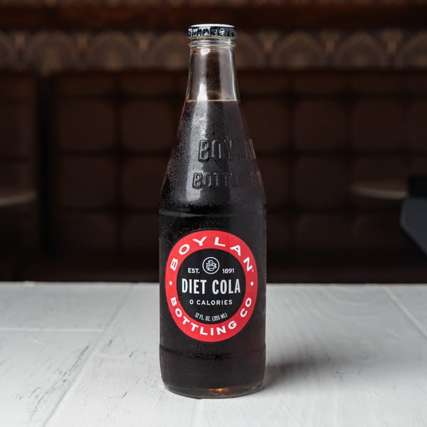 A cold, condensation-covered bottle of Boylan Diet Cola sits on a white table.