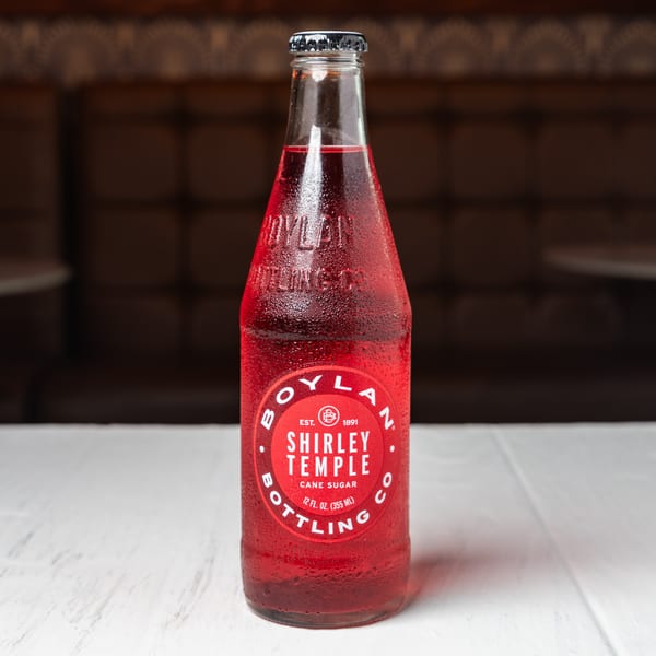 A cold bottle of Boylan Bottling Co. Shirley Temple soda on a white table.